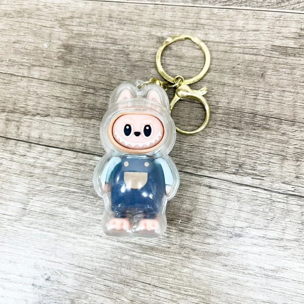 Labubu Monster Art Toy Keychain Blue Overalls Clear Protective Case Gold Tone